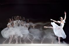 a ballerina is dancing in front of a group of dancers