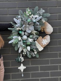 a wreath on the side of a building with mittens and snowflakes