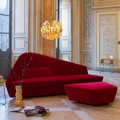 an elegant living room with red couches and chandelier