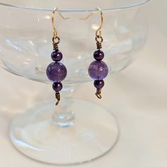 Purple drop earrings, featuring glass beads flanked by small purple pearls. Wire wrapped with bronze-colored wire. Simple but elegant design. Can be worn casual or dressy. 1 inch drop Elegant Lavender Beaded Drop Earrings, Purple Wire Wrapped Czech Glass Jewelry, Elegant Hypoallergenic Beaded Earrings With Czech Glass, Elegant Wire Wrapped Crystal Earrings With Round Beads, Elegant Wire Wrapped Round Crystal Earrings, Elegant Bronze Beaded Earrings For Gift, Hypoallergenic Purple Beaded Earrings, Elegant Purple Round Bead Crystal Earrings, Purple Wire Wrapped Beaded Earrings For Gift