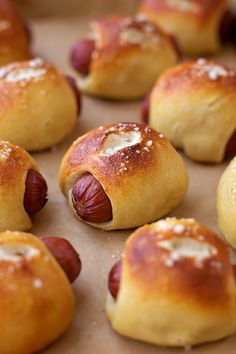 several hot dogs wrapped in bread on a baking sheet