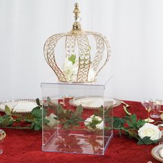 there is a crown on top of a table with flowers and plates around it,