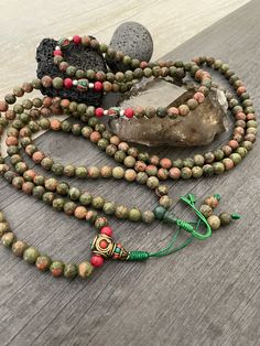 Unique and powerful Unakite Jasper stone Japa mala Necklace from Nepal. A unisex piece that will be perfect for your day by day outfits and will be easy to match any other accessories. If it fits right can be a bracelet also. This is also a Buddhist praying 108 beads mala, you can use this mala to stay grounded and meditate and also to stay in fashion at the same time. You can loosen up the beads to make it easy to meditate with the mala. The mala is 42.5cm- 16.75 inch long A unique addition to Green Hand-strung Spiritual Mala, Green Spiritual Mala With 108 Beads, Spiritual Multicolor Jasper Necklaces, Multicolor Jasper Spiritual Necklace, Adjustable Green Spiritual Mala, Green Adjustable Spiritual Mala, Bohemian Hand Wrapped Mala With Round Beads, Spiritual Green Hand Wrapped Beads, Handmade Spiritual Jasper Beaded Necklaces