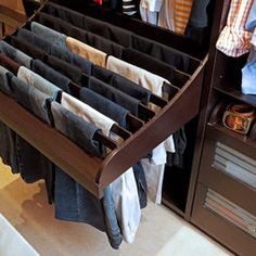 an open drawer with clothes hanging on it