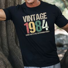 Celebrate Your 40th with a Laugh! (Not the right year? Just message us before ordering) Step into your milestone year with humor and style in our "Vintage 1984 - Some parts still in working order" Gildan 5000® T-Shirt. Perfect for men celebrating their 60th birthday, this tee combines comfort with a witty twist, making it a fantastic gift for those who appreciate a good laugh. Made from 100% cotton, it's soft, durable, and sure to become a favorite in any wardrobe. Embrace the vintage vibes and show the world that even at 40, you're still going strong! Product Details: Material: 100% cotton (preshrunk) Fit: Classic fit, true to size Sizes: S-5XL Why You'll Love It: Comfortable: Soft and breathable fabric for everyday wear Durable: High-quality print that withstands many washes Fun Design: Forty Birthday, 70th Birthday, Fun Design, 60th Birthday, Vintage Vibes, 50th Birthday, Gift For Men, Fantastic Gifts, Tshirt Colors