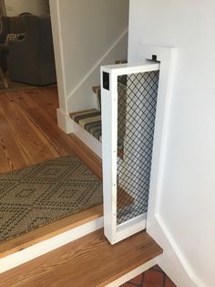 a dog door is open on the floor next to a stair case in a house