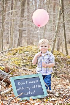 a little boy holding a pink balloon and a sign that says don't mess with my little sister