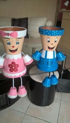 two paper dolls sitting on top of a table