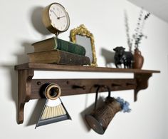 there is a shelf with books and an alarm clock on it, along with other items