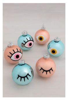 six ornaments with eyes and eyelashes on them