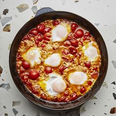 an iron skillet filled with eggs and tomatoes