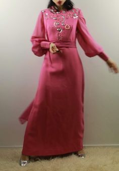 Vintage 70s pink maxi evening dress with voile big sleeves and hight cuffs. Silver geometric decoration. Comes with a extra long voile scarf. Best fit size 10 uk Shoulder to shoulder 37 cm Cheat 42 cm Waist 38,5 cm Hips 50 cm Length 141 cm Model's size 6 UK, h 163 cm Excellent vintage conditions. Shipping of this item takes one week for dry cleaning. I wish the dress is perfect for you! All items are vintage and used. However they are all in good to excellent condition. Any defect is specified. Long Pink Dress For Eid, Pink Long Dress For Eid, Pink Long Sleeve Evening Dress For Banquet, Long Sleeve Pink Evening Dress For Banquet, Festive Pink Long Sleeve Abaya, Festive Long Pink Abaya, Pink Long Maxi Dress For Eid, Long Pink Party Dress, Pink Floor-length Party Abaya