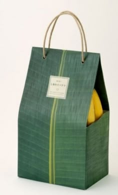 a green bag filled with fruit sitting on top of a white table