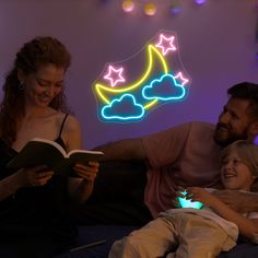 a man, woman and child sitting on a bed reading a book