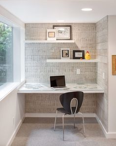 a laptop computer sitting on top of a white desk next to a wall mounted shelf