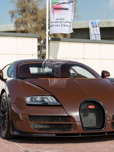 a brown bugatti parked in front of a building