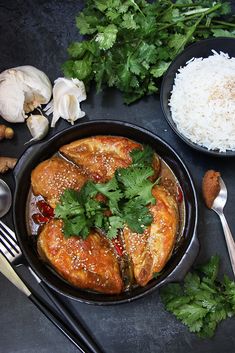 a pan filled with chicken and rice next to some chopsticks on the side