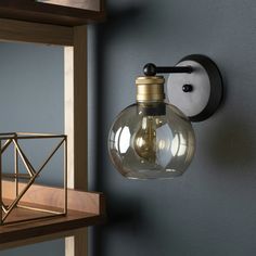 a light that is on the wall next to a book shelf with bookshelves