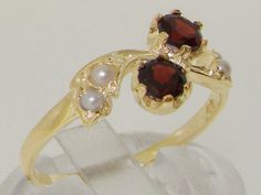 a gold ring with two garnets and pearls