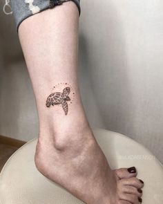 a woman's foot with a small turtle tattoo on her left side calfocks