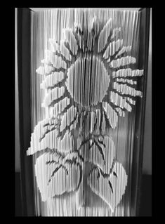 an intricately designed vase is shown in black and white, with folded papers on the bottom