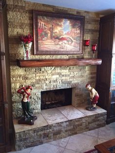 a living room with a fire place and painting on the wall above it's mantle