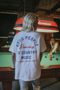 Put Johnny on the vinyl to get all the cowboys and cowgirls on the dance floor. We love when good people are boot scootin' to country music. This white tee features a fun blue and red front and back graphic. Fun T Shirts For Women Graphic Tees, Free People Tshirt, Western Graphic Tees Outfit, Red Tee Outfit, Austin City Limits Outfit, Chic Western Outfits, Hippie Cowgirl Style, Merch Shoot, Country Party