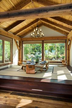 the inside of a house with wooden beams and windows on each side, in an open floor plan