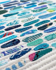 a close up of a piece of fabric with different colored patches on it and the words stitched together