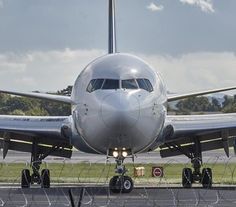 an airplane sitting on the tarmac with its lights on and it's landing gear down