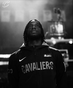 a man with dreadlocks standing in front of a microphone and lights behind him