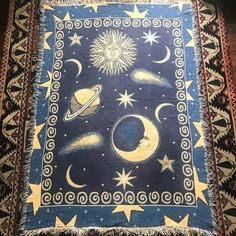 a rug with stars, planets and the sun on it is hanging from a wall