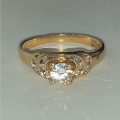 an image of a gold ring with diamonds on the sides and in the middle it is sitting on a white surface