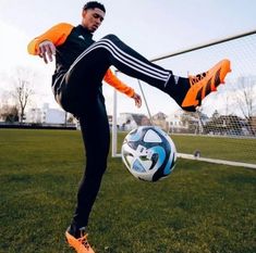 a man kicking a soccer ball on top of a field