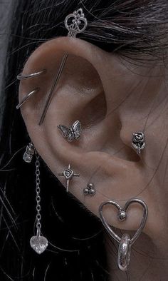 a woman wearing ear piercings with hearts and crosses on it's side, behind her ear