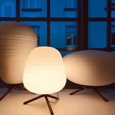 three white lamps sitting next to each other in front of a window