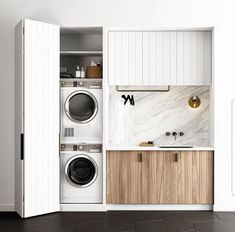 a washer and dryer in a small space with cabinets on either side, next to a sink