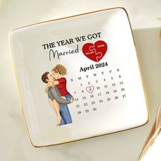 a plate with a calendar on it and a couple holding each other in their arms