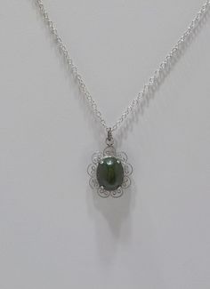 "Vintage olive green jade (new jade) pendant necklace. 15\" silver tone chain with a spring fastener. Sterling filigree frame holds an olive green prong set jade cabochon. Excellent condition." Silver Jade Necklace With Oval Pendant, Oval Jade Cabochon Necklace, Silver Necklace With Jade Cabochon, Handmade Oval Jade Pendant, Vintage Green Jade Necklaces, Elegant Nickel-free Jade Necklaces, Vintage Jade Round Pendant Jewelry, Silver Jade Cabochon Necklace, Carved Silver Jade Necklace