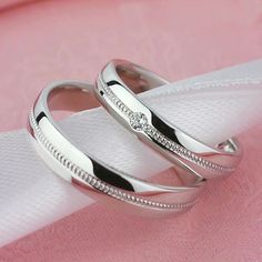 two wedding rings sitting on top of each other