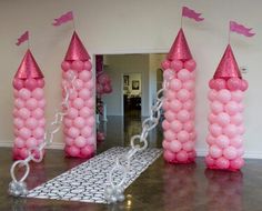 some pink balloons are in the shape of towers