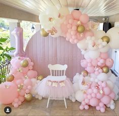 pink and gold balloon arch with white chair