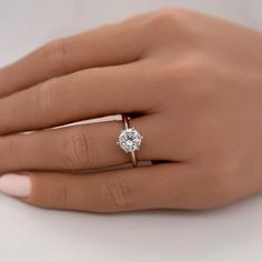 a woman's hand with a diamond ring on it