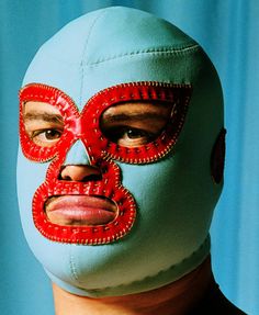 a man wearing a blue mask with red stitches on it's face and eyes