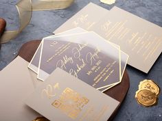 the wedding stationery is laid out on top of each other, with gold foil