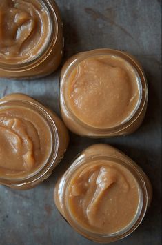 four jars filled with peanut butter sitting on top of a table