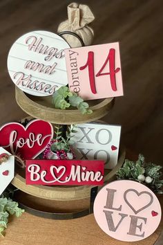 three tiered cake decorated with valentine's day decorations and handmade tags on top