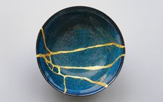 a blue bowl with gold lines painted on it