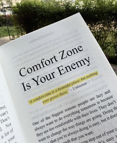 an open book with the words comfort zone is your enemy on it's page