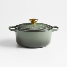 a green casserole with a gold lid